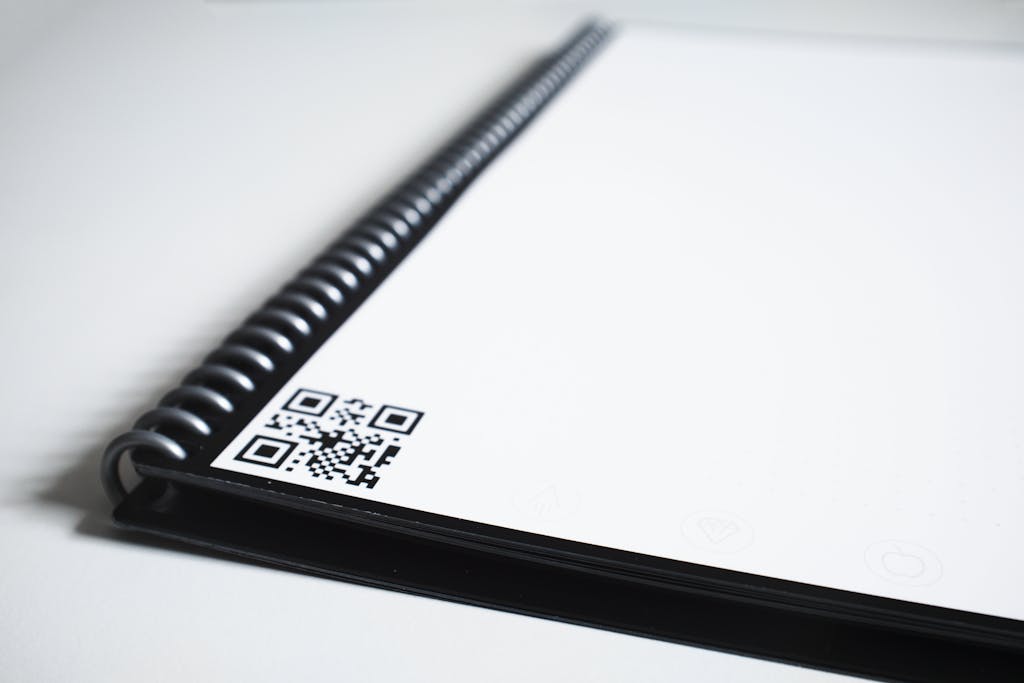 "QR code on a notebook page representing Digital Gravestones' StoneCode product for interactive digital memorials."