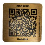 Brushed gold metal QR code plaque for a digital memorial on a white background.
