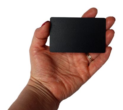 Black bamboo wooden NFC card for a digital memorial, held in hand to show size on a white background.