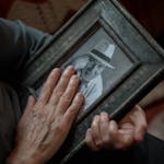 Close-up of a senior man's hands holding a nostalgic photo.